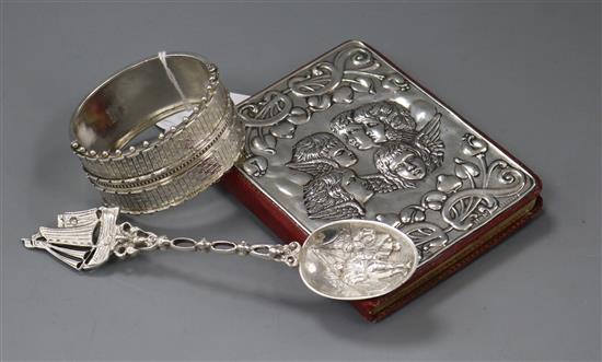 A late Victorian ornate silver bangle (a.f.), a silver mounted day book and a Dutch white metal spoon.